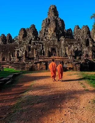 2 munkkia Bayon-temppelin edessä Angkorissa Kambodžassa